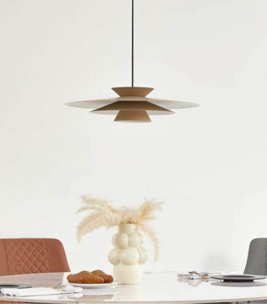 Moderne Pendelleuchte über Esstisch mit warmen Naturtönen und zeitlosem Design.