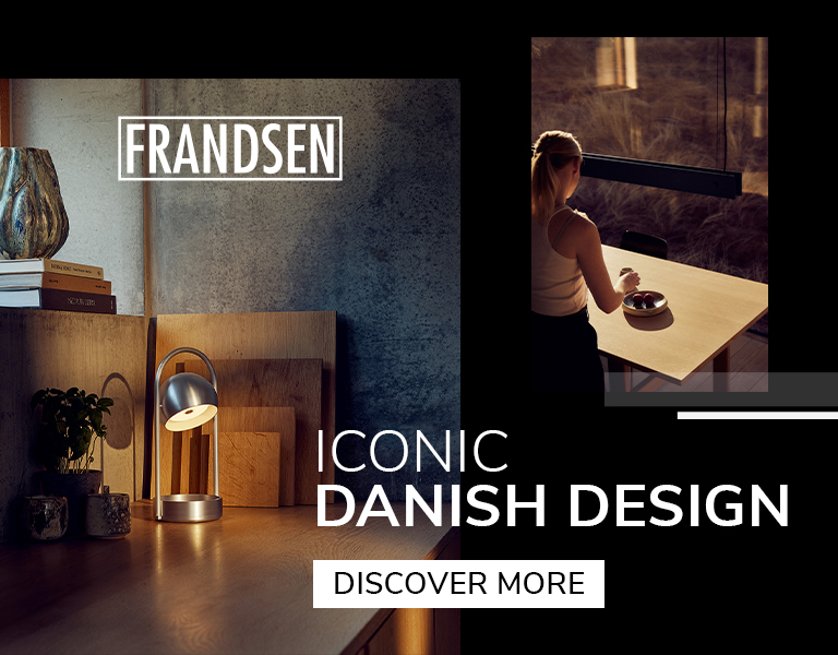 Discover More Nordic interior with a metallic Frandsen table lamp and Scandinavian dining area, promoting iconic Danish lighting design.